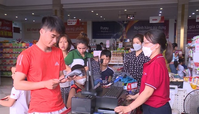 anh Trần Minh Hoàng (áo đỏ), xã Quảng Văn, huyện Quảng Xương thanh toán tiền qua thẻ ATM.