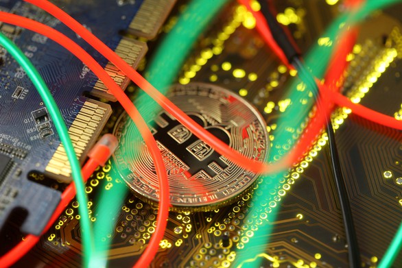 Đồng Bitcoin trên bộ vi mạch máy tính - Ảnh: REUTERS
