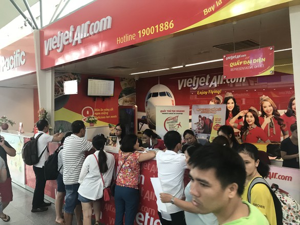 Hành khách bị đổi chuyến bức xúc tập trung trước quầy của hãng VietJet tại sân bay Đà Nẵng - Ảnh: TRƯỜNG TRUNG