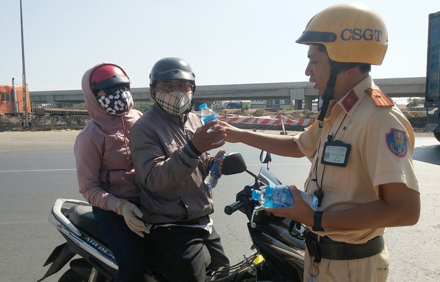 CSGT tặng nước suối, khăn lạnh cho người đi xe máy về quê ăn Tết - 1