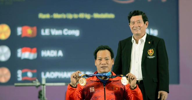 Ðô cử Lê Văn Công nhận Huy chương vàng môn cử tạ hạng dưới 49kg nam và nhận thay Huy chương vàng của đô cử Bình An (bị chấn thương) ở hạng cân dưới 54kg. (Ảnh THÁI DƯƠNG)